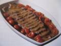 Plato de carne asada con salsa y tomates cherry.