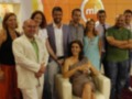 Equipo de televisión posando junto a una presentadora durante un programa de entretenimiento.
