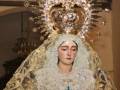 Imagen de una imagen de la Virgen María con una corona de estrellas y un manto bordado con un crucifijo en el centro.