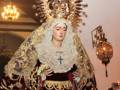 Imagen de una figura religiosa en traje de luto con corona dorada, representando a la Virgen de la Soledad, en un ambiente de iglesia.