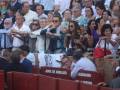 Asistentes en una corrida de toros en Sevilla, España, con la Junta de Andalucía en el fondo.