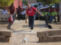 Un jugador participa en una partida de boliche, lanzando una bola hacia el objetivo.
