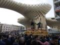 Ceremonia religiosa en Sevilla, con una procesión de la Virgen de la Candelaria en el centro de la imagen, bajo el famoso arco de la Metropol Parasol.