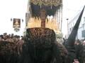 Una procesión religiosa con personas vestidas con trajes tradicionales y sombreros largos.