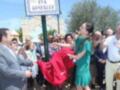 Eva González corta una banderola en la inauguración de la Avenida Eva González, con un grupo de personas observando.