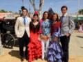 Familia en trajes típicos de feria en España, con vestidos de flamenca y trajes de hombre formales.