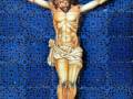 Crucificado Jesús en la cruz, detalles de la figura y el fondo azul.