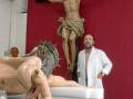 Un hombre observa una escultura de Cristo crucificado en una iglesia.