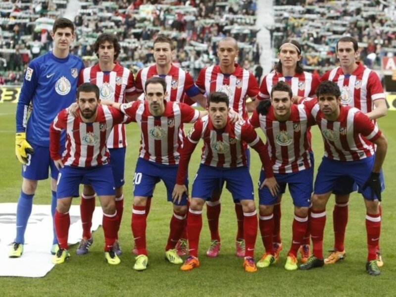 Equipo de fútbol posando en el campo de juego.