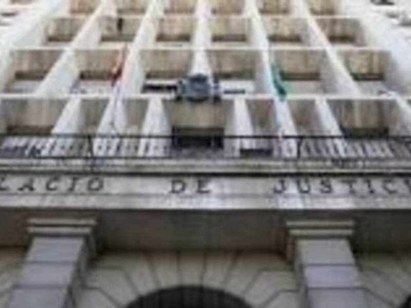 Edificio de oficinas con el nombre "Palacio de Justicia" en la fachada. Bandera ondeando en un balcón.