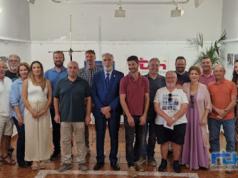 Grupal de personas en una reunión o evento formal en un espacio bien iluminado.