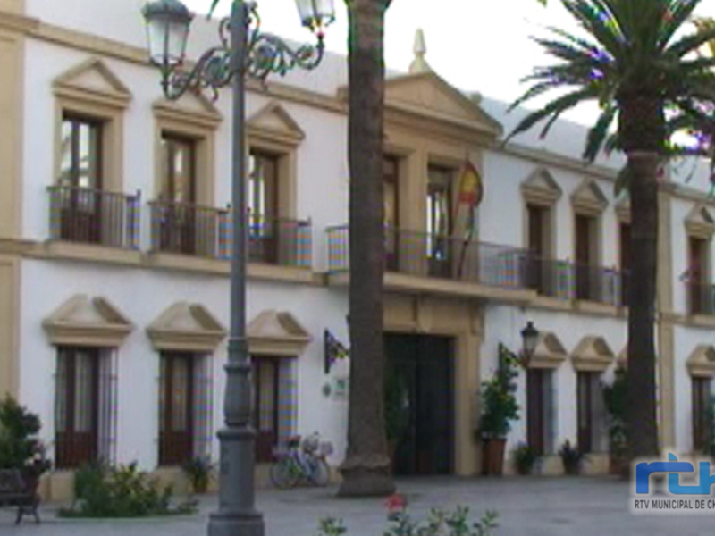 Fachada colonial de un edificio histórico, con balcones y palmeras en el frente.