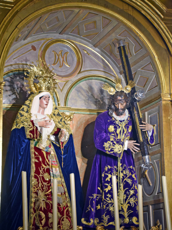 Imágenes religiosas de la Virgen de la Soledad y el Cristo de la Buena Muerte en un altar ornado.