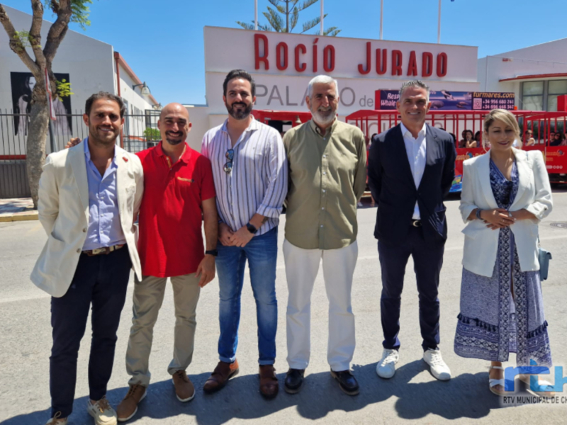 Grupo de personas posando frente al Palacio de las Ballenas en Chipiona, España.