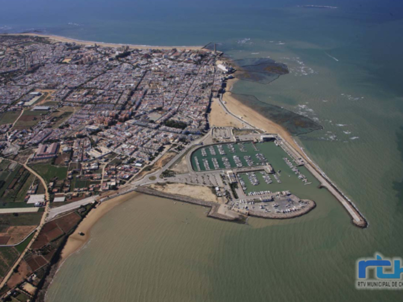 Vista aérea de Chipiona, con su puerto y extensas playas costeras.