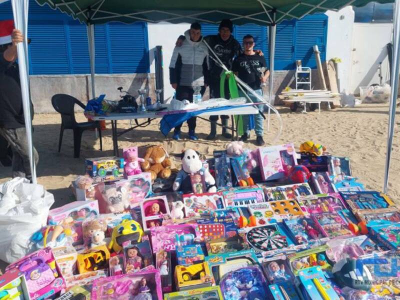 Voluntarios organizan una donación de juguetes en la playa para niños en Navidad.