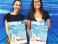 Dos personas sonrientes sosteniendo pósters del Campeonato de España de Waterpolo Juvenil por Clubes 2023, celebrando el evento deportivo.