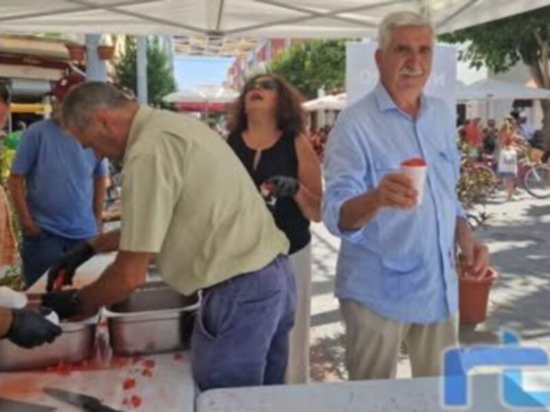 Una escena de mercado callejero con personas comprando frutas y verduras.