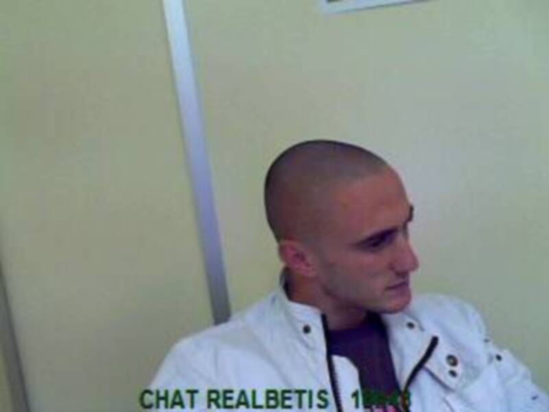 Un hombre con una camisa blanca y un jersey negro está hablando en un chat.