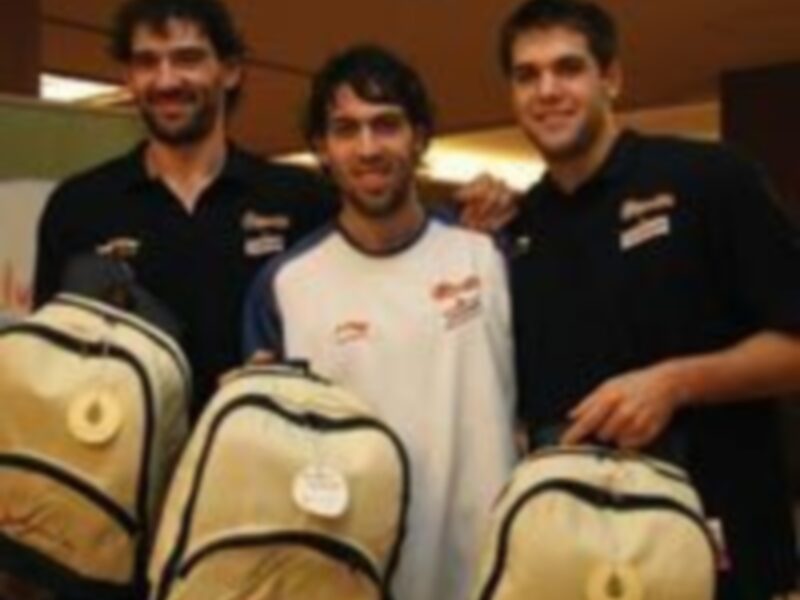 Tres personas sonrientes posando con bolsas de deporte en un entorno interno.