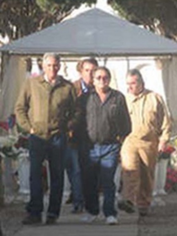 Personas caminando cerca de un toldo en un entorno al aire libre.