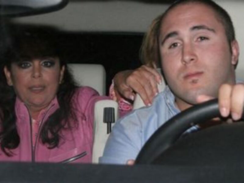 Dos personas en un coche, una mujer con maquillaje y una persona masculina.