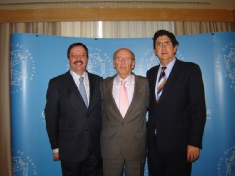 Tres hombres vestidos con trajes posan frente a un fondo azul con el logo de la Oficina del Presidente.