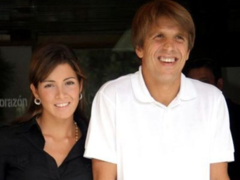 Dos personas sonrientes, una mujer con cabello largo y una persona en blanco.