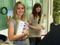 Dos mujeres en una oficina, una sosteniendo un folleto con información sobre el AIO (Acceso a la Información de Oportunidades).