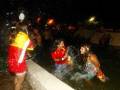Jóvenes disfrutando de una fuente en la noche, con luces brillantes y un ambiente festivo.