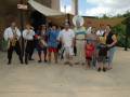 Una banda musical y una familia posan en un parque, con instrumentos musicales como saxofón, trompeta y batería. La familia incluye niños y adultos vestidos de manera casual, posando con orgullo frente a la banda.