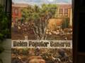 "Belén Popular Canario" muestra una escena pastoral con animales y arado, ilustrando la tradición navideña en el archipiélago canario.