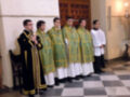 Un grupo de jóvenes sacerdotes en trajes litúrgicos esperando durante una ceremonia religiosa.