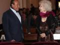 Silvio Berlusconi y una mujer anciana sonríen mientras se encuentran en un evento formal.