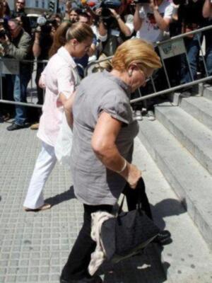 Una mujer camina por una calle mientras otros la observan.