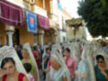 Folkloric procession with women in traditional white lace veils, possibly during a religious or cultural event.