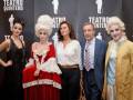 Personas posando en un evento teatral, con disfraces históricos y fondo de cartel del Teatro Quintero.