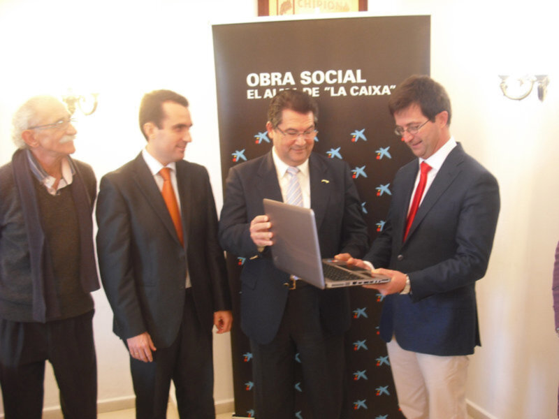 El alcalde entrega un ordenador y  alimentos donados por La Caixa a la fundación Faros (Chipiona)