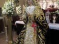 Imagen de una Virgen María vestida con trajes tradicionales y adornos, posiblemente durante una celebración religiosa o procesión.