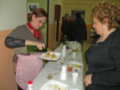 Mujeres disfrutando de una comida en una reunión social, compartiendo platos y conversando.
