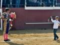 Un niño en una corrida de toros, entregando flores a un torero.