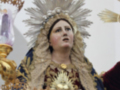 Una figura religiosa vestida con trajes tradicionales y un halo. La escena parece ser de una iglesia o templo, con elementos decorativos que sugieren un ambiente sagrado.
