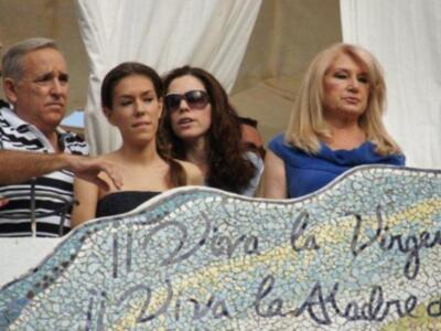 Una familia observa desde una plataforma decorada con mosaicos, incluyendo un mensaje que dice "Viva la Madre de Dios".