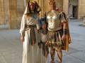 Personajes disfrazados de Egipto y Roma en un patio histórico.