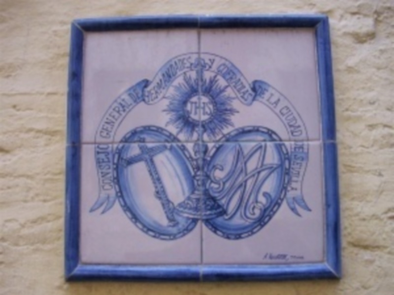 Azulejo con diseño de tambor y sol, texto en inglés.