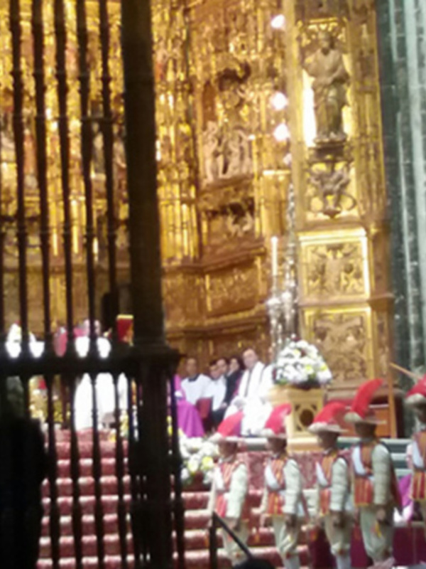 Interior de la Catedral de Segovia, España, con detalles dorados y una procesión religiosa en el fondo.