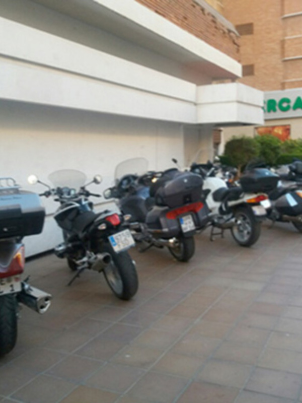 Motos aparcadas en una calle con edificios de fondo en un entorno urbano.