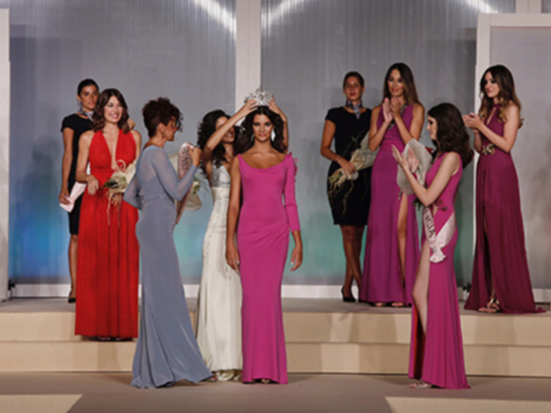Concurso de belleza con participantes en vestidos de gala, celebración de elegancia y belleza.