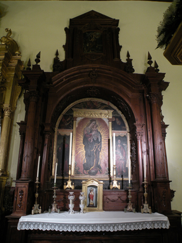 Altar de madera tallada con una imagen central de la Virgen María, rodeada por detalles artísticos y decoración.
