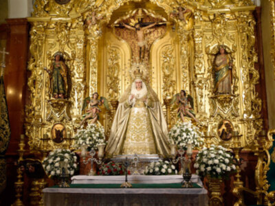La Virgen  de las Angustias de la Hermandad de la Vera-cruz de Alcalá del Río vestida de blanco en tiempo estival.